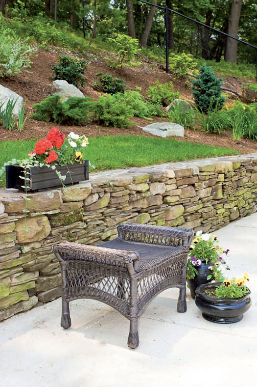 Облагородить подпорные стенки помогают различные способы кладки камня и цветочные композиции